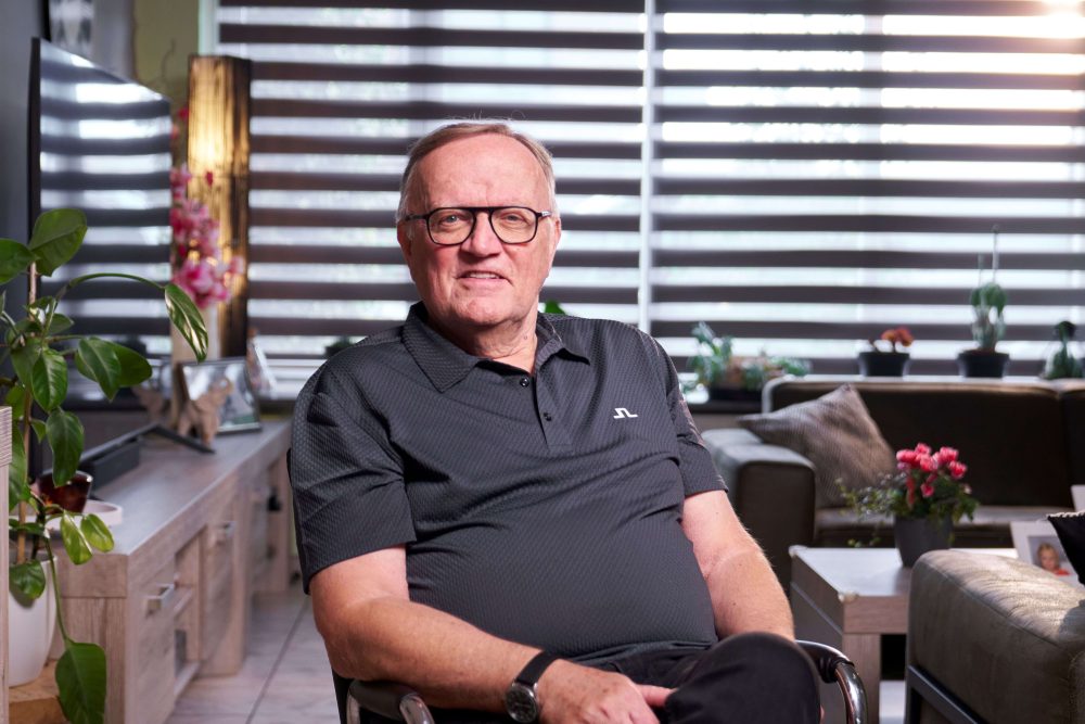 Portret van oud-prostaatkanker patient Hans van den Bosch zittend op een stoel in zijn woonkamer
