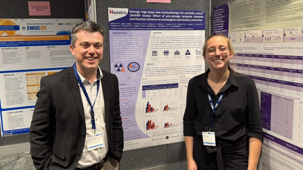 Evert van Limbergen en Iris Laven poseren voor een poster die ze tijdens de EMUC 2025 presenteren