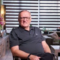 Portret van oud-prostaatkanker patient Hans van den Bosch zittend op een stoel in zijn woonkamer