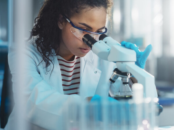 Stockfoto van een onderzoeker achter een microscoop