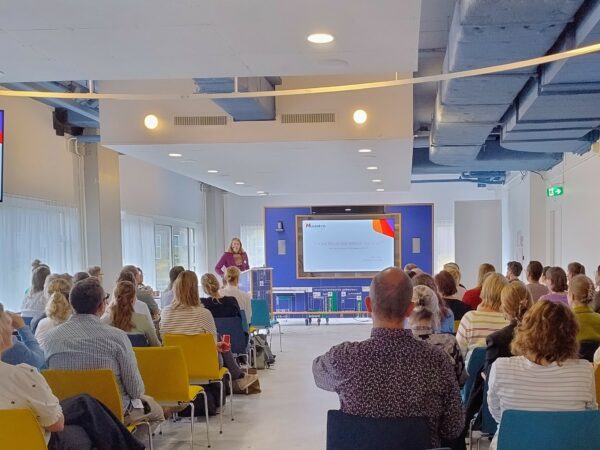 Landelijke brachydag voor specialisten in Rotterdam, Erasmus ziekenhuis. Vooraan in de zaal geeft Malou Kuppen een presentatie