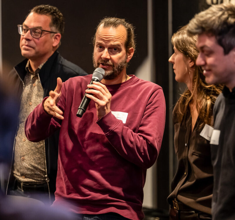 Prof dr Andre Dekker stelt een vraag aan een van de sprekers.
